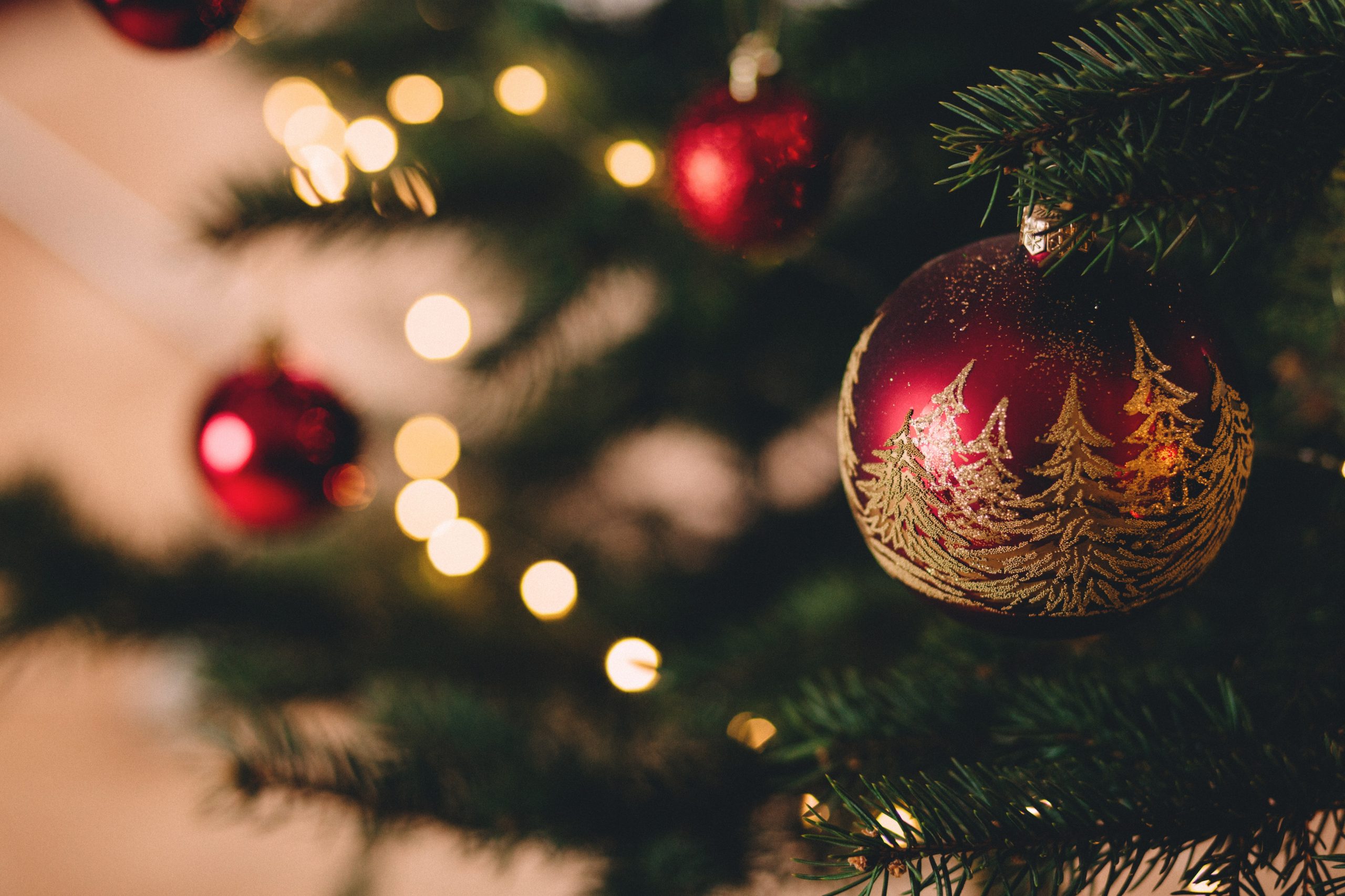 Foto de bolinhas de Natal presos à uma árvore de Natal para a pauta "Cuidados na decoração natalina do seu apartamento" do Blog da Estasa